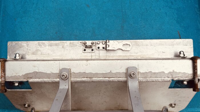 Aluminium motorfäste med bultar och gångjärn i en båt.