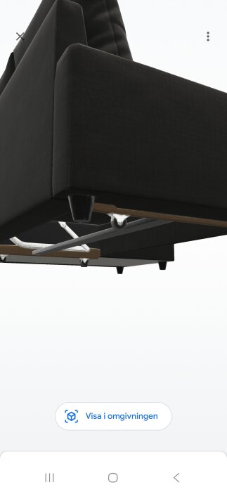 Svart bäddsoffa sedd underifrån med fokus på benen och hjulens position i förhållande till marken.