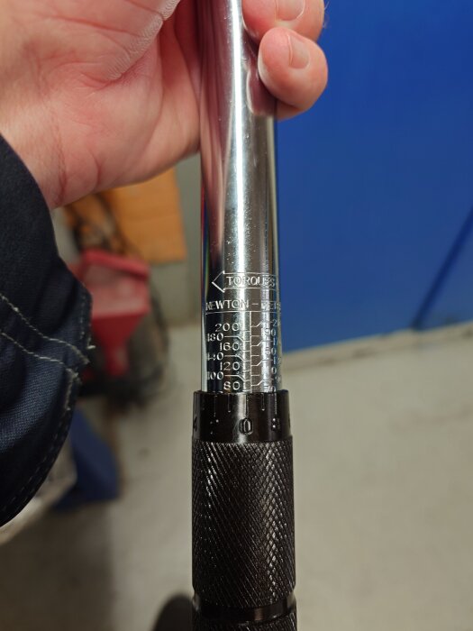 En hand håller i en momentnyckel med skala i Newtonmeter.