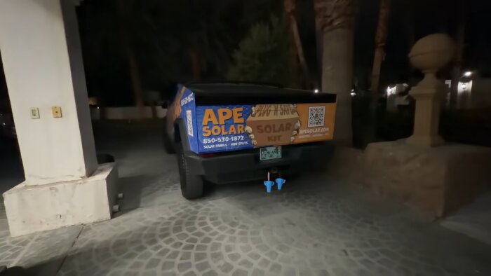 Lastbil med reklam för solpaneler, med två blå hitch balls synliga vid dragkroken.