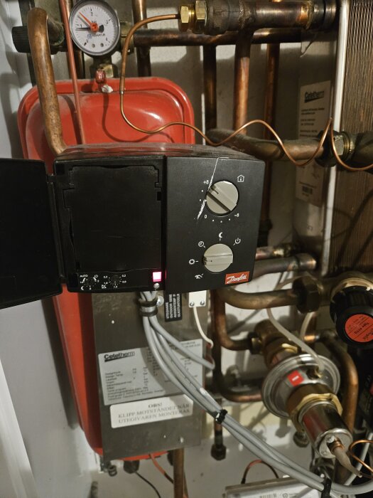 Värmesystem med tryckmätare, rör och Danfoss-reglage, utan manual.