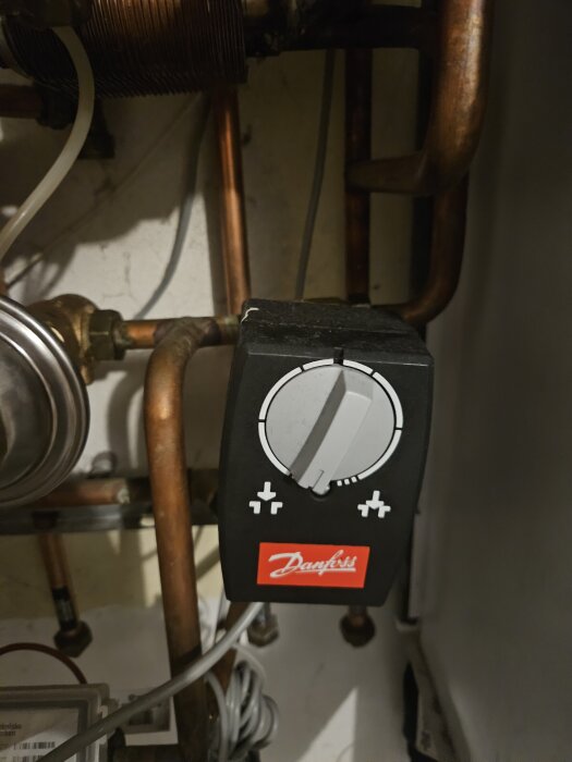 Kontrollpanel från Danfoss med rör och kopplingar, troligen en del av värmesystem.