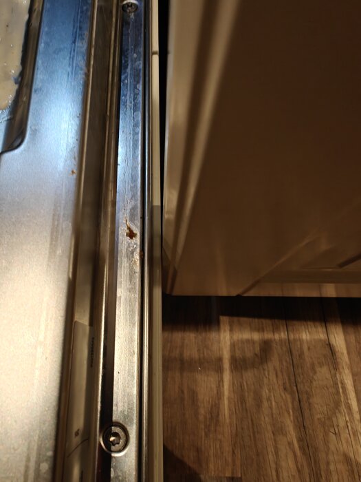 Närbild på en skena i en kökslåda med eventuellt trasiga kullager, metall och trädetaljer syns.