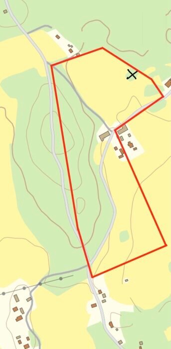 Karta över markerat område med röd linje, visar skog och åkermark nära vägar och bostäder, markerad skogsdunge med ett kryss.