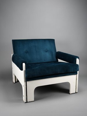 Blå och vit fåtölj i retrodesign med vita sidostycken och stoppade armstöd och ryggstöd, liknar en Jan Pieter Berghoef-modell.