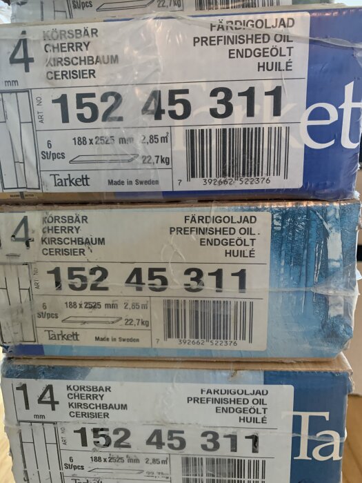 Kartonger med Tarkett Trägolv Körsbär, märkta med "Färdigoljad" och "Körsbär", innehåller 6 bitar per kartong, tillverkade i Sverige.