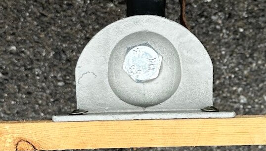 Fäste för dragkrok med stor bult monterad på en platta. En träbräda sitter nedanför som testplacering för en ramp.