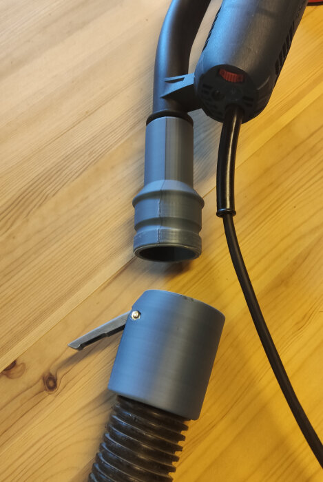 Slipmaskin med dammsugaradapter från printables ansluten till en slang på ett träbord.