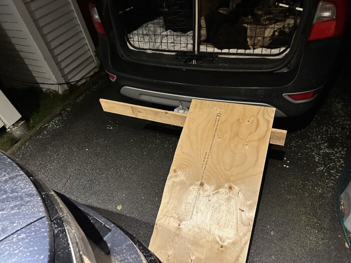 Bräda placerad på dragkrokens fäste bak på en bil, används för att testa en ramp för hundar.