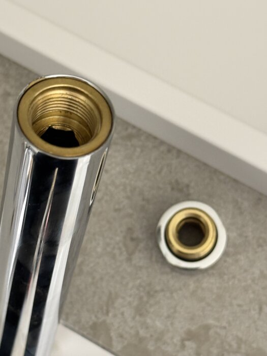 Takduschens rör med fäst hylsa, där hylsan är lös men svår att lossa.