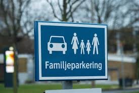En blå skylt med texten "Familjeparkering" och ikoner föreställande en bil och en familj med två vuxna och två barn.