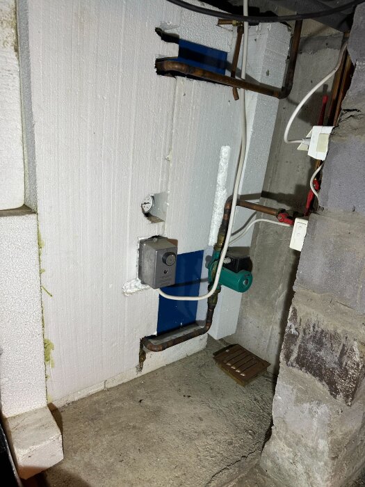 Krypgrund med rör och värmepump markerad med pil; inkluderar isolering och rörkopplingar.