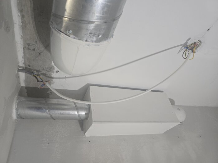 Ventilationsrör och ledningar i ett tak under renovering, med synliga anslutningar och kabeldragningar.