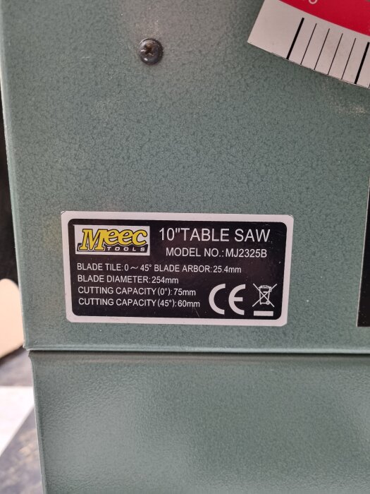 Etikett på en Meec Tools 10-tums bordssåg, modell MJ2325B, med tekniska specifikationer som bladvinkel och kapacitet.