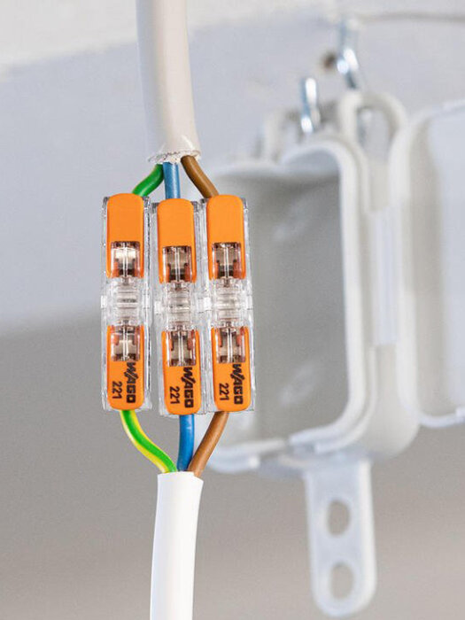 Elektrisk kopplingsbox med tre Wago-kontakter som förbinder flera kablar i taket.