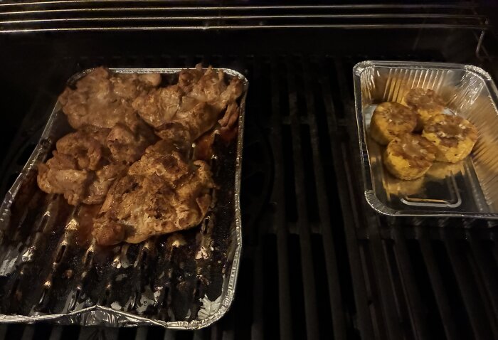 Kycklingstekar och grillad majs tillagas på en grill i aluminiumformar.