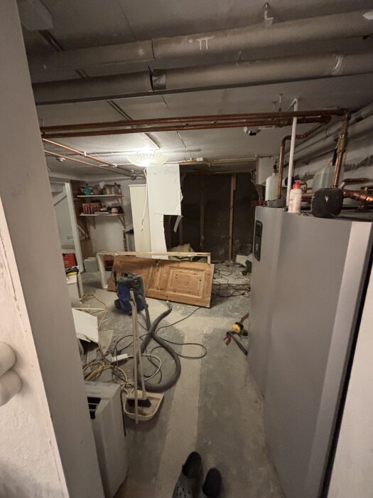 Rivning av gammalt badrum, verktyg och material på golvet.