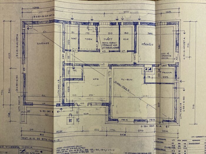 Planritning över ett soutteränghus med rum markerade som garage, mat, tork, förråd, WC, KPR, TV-rum och panna; dimensioner anges.