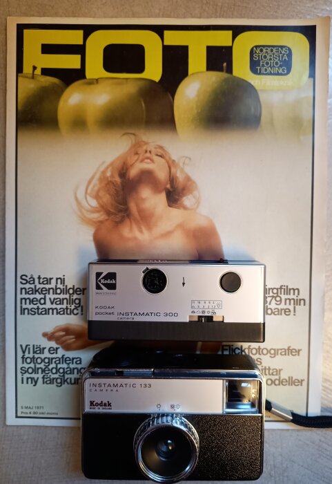 Kodak Instamatic-kameror från 1970-talet, modell 300 och 133, placerade på ett gammalt nummer av tidningen FOTO.