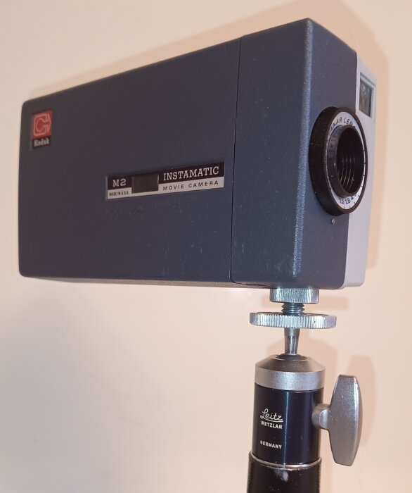 Kodak Instamatic M2 super åtta filmkamera från 1960-talet monterad på ett Leitz stativ med metall- och plastdetaljer.