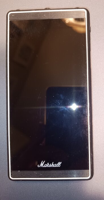 Smarttelefonen Marshall London, frontal vy med svart skärm och Marshall-logotyp på svart bakgrund.