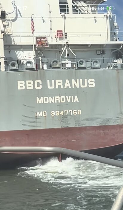 Fartygssida med texten "BBC URANUS" och "MONROVIA", registreringsnummer IMO 9947768, med vatten i förgrunden.