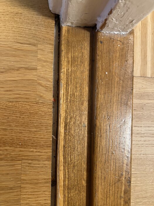 Glipa mellan parkettgolv och gammal tröskel i lägenhet.