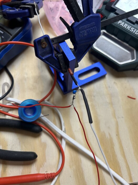 Klämmor och kablar i ett DIY-elprojekt på arbetsbänk.