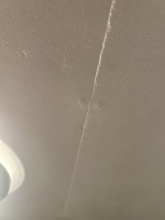 Betongvägg med synlig skarv och spikmärken utanför tvättstugan.