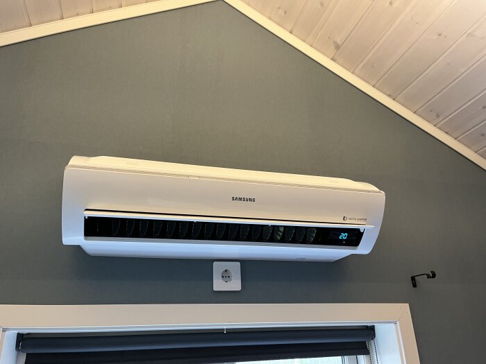 Samsung luftvärmepump monterad på en vägg i ett gästhus, med en rattling fläkt och svårt att ta bort plastkåpan, söker hjälp för att lösa problemet.