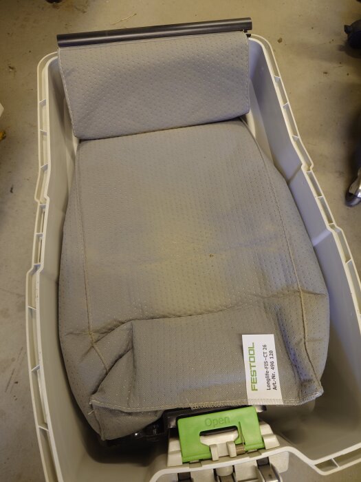 Grå dammsugarpåse i en plasthållare för Festool CTL26 visas upp.