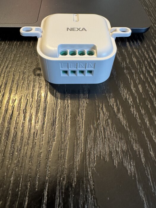 NEXA fjärrstyrd brytare MCMR-2000 med fyra kabelportar (L, L, N, N) på svart bord.