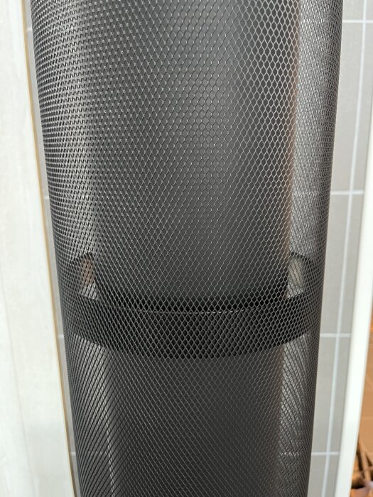 Oisolerat rökrör modifierat med finmaskigt galler av sträckmetall för ökad värmespridning från kamin i stuga.