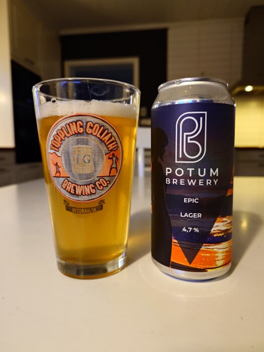 Ett glas öl från Toppling Goliath Brewing Co och en ölburk från Potum Brewery Epic Lager 4,7 % på ett bord i ett kök.