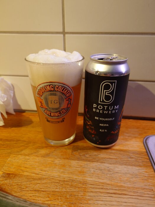 Ett glas öl från Toppling Goliath Brewing Co. bredvid en ölburk från Potum Brewery med texten "Be Yourself NEIPA 6,5%".