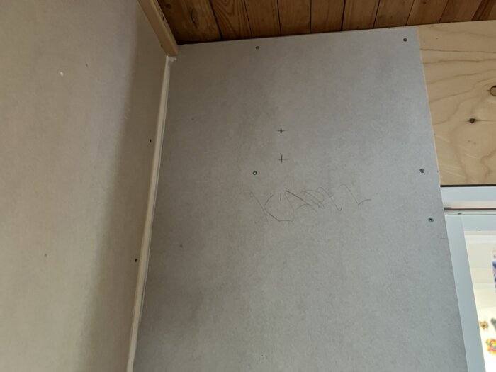 Närbild av en vägg med handskriven text "Kabel" och markeringar, vilket visar plats för dold kabeldragning.