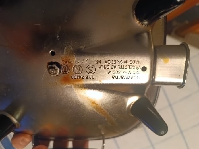 Baksidan av en Husqvarna-apparat med märkning och anslutning, frågan gäller om det borde vara en jordad kontakt.