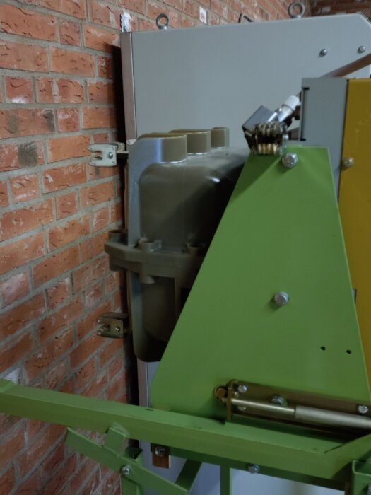 En KAFAK Merlin Gerin Fluarc FG 1 effektbrytare, 12kV 630A från 1988, monterad på en tegelvägg med gröna metalldelar.