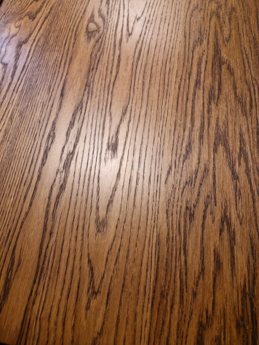 Stavlimmad ekplanka med mörk träådring visas, som matchar inredningsfärgen.