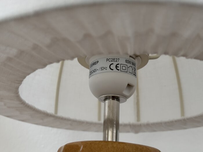 Närbild av en lampsockel med CE-märkning och specifikationer för 220-240V och 60W max effekt.