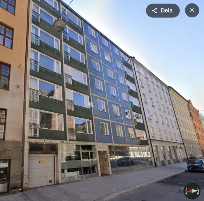 Flerfärgat hyreshus från 1963 med modernistisk stil på Roslagsgatan 60 i Stockholm, med fönster i rutmönster och olika färgade paneler.