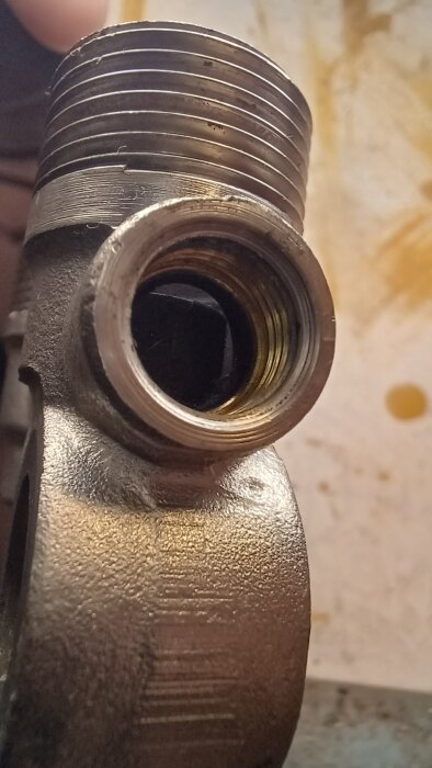Närbild av ett demonterat 1-rörskoppel från en AGA Termopanel med gängade detaljer, använd för att studera innanmätet av radiatorventilen.