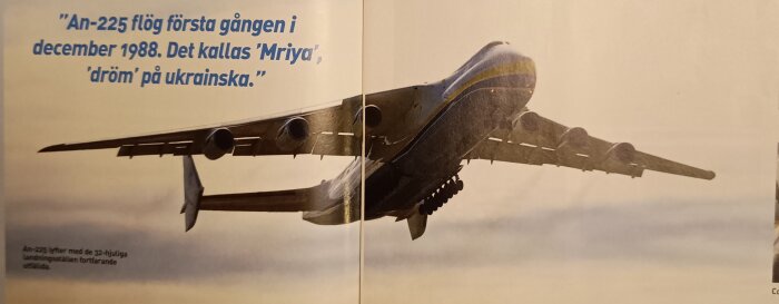 Ett An-225 flygplan lyfter med landningsställen kvar ute, med text om dess första flygning och betydelsen av namnet "Mriya".
