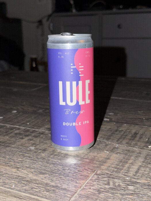 En burk Lule Brew Double IPA, blå och rosa design, står på ett träbord.