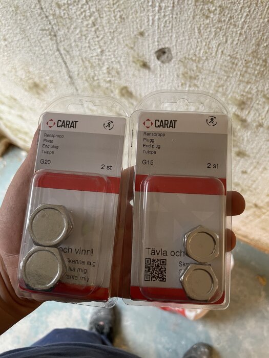 Förpackningar med rensproppar i storlekarna G20 och G15 från Carat, hållna i hand.