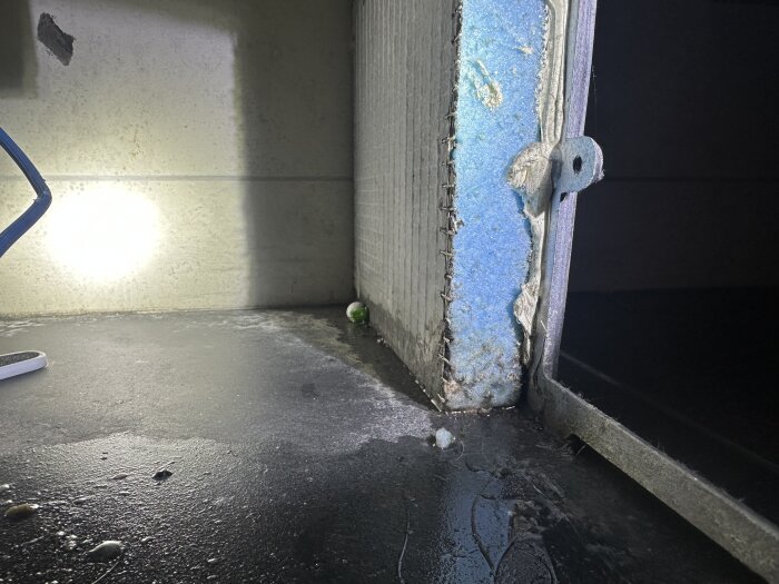 Inspektionslucka där blå XPS-/cellplastskivor syns i en konstruktion runt ett hörn-spabad i ett badrum.