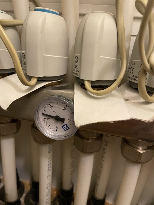 Ventiler och rör med termostatdelare och temperaturmätare.