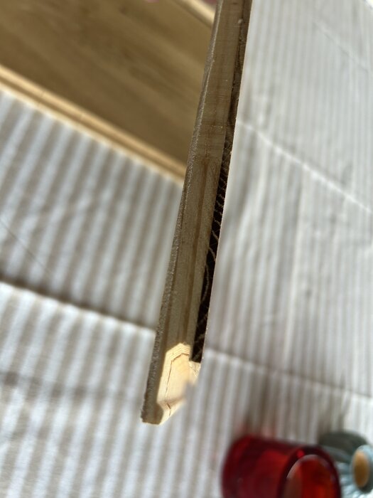 Närbild av kanten på en parkettgolvsbräda, som visar dess struktur och lager uppifrån sett.