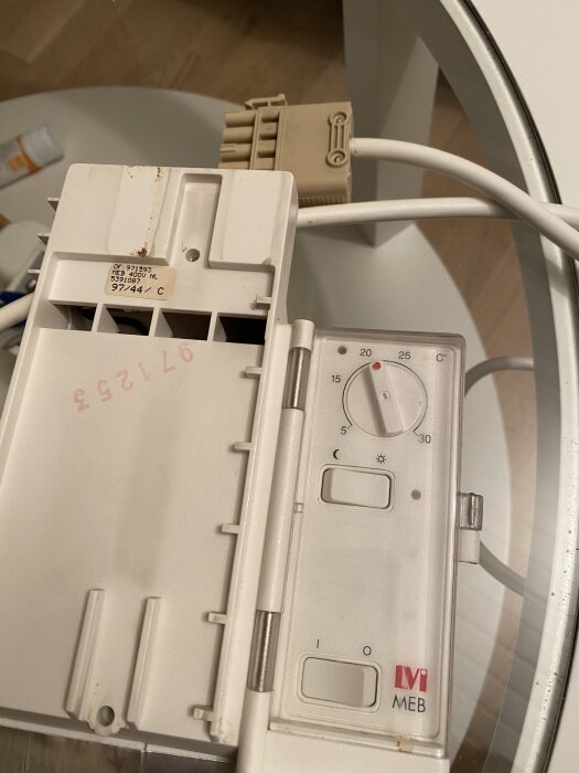 Termostat från MEB med vred för temperaturinställning och anslutna kablar på ett glasbord.