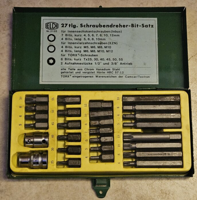Borrbits-set i en grön ask från märket Eldi, inklusive hylsor och olika storlekar av bits, med 1/2 och 3/8 infästningar för skruvdragning.